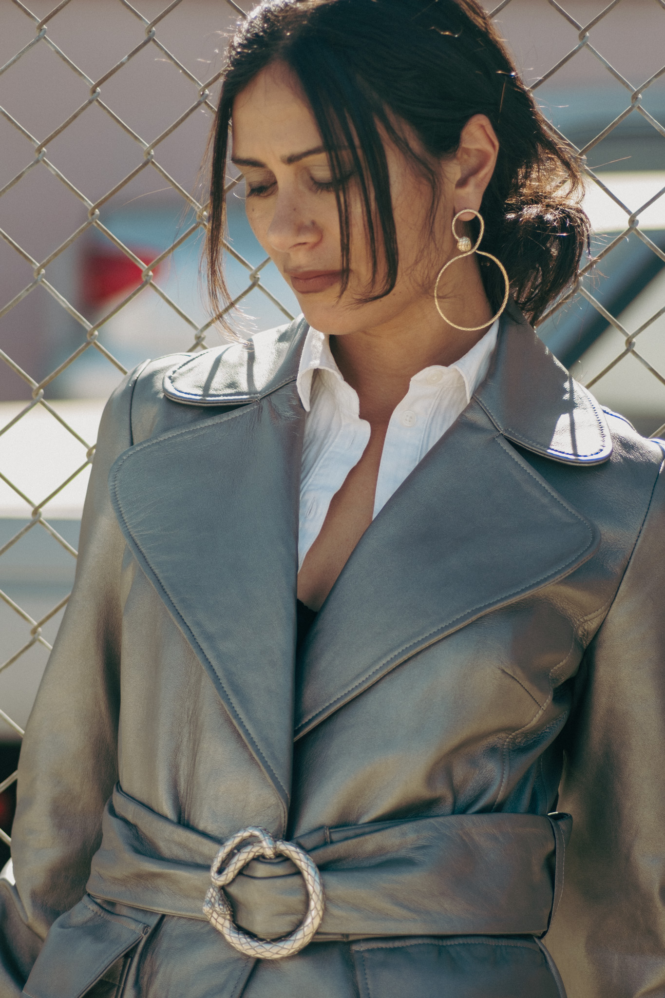 Silver leather trench, eyes down, serpent hoop earring