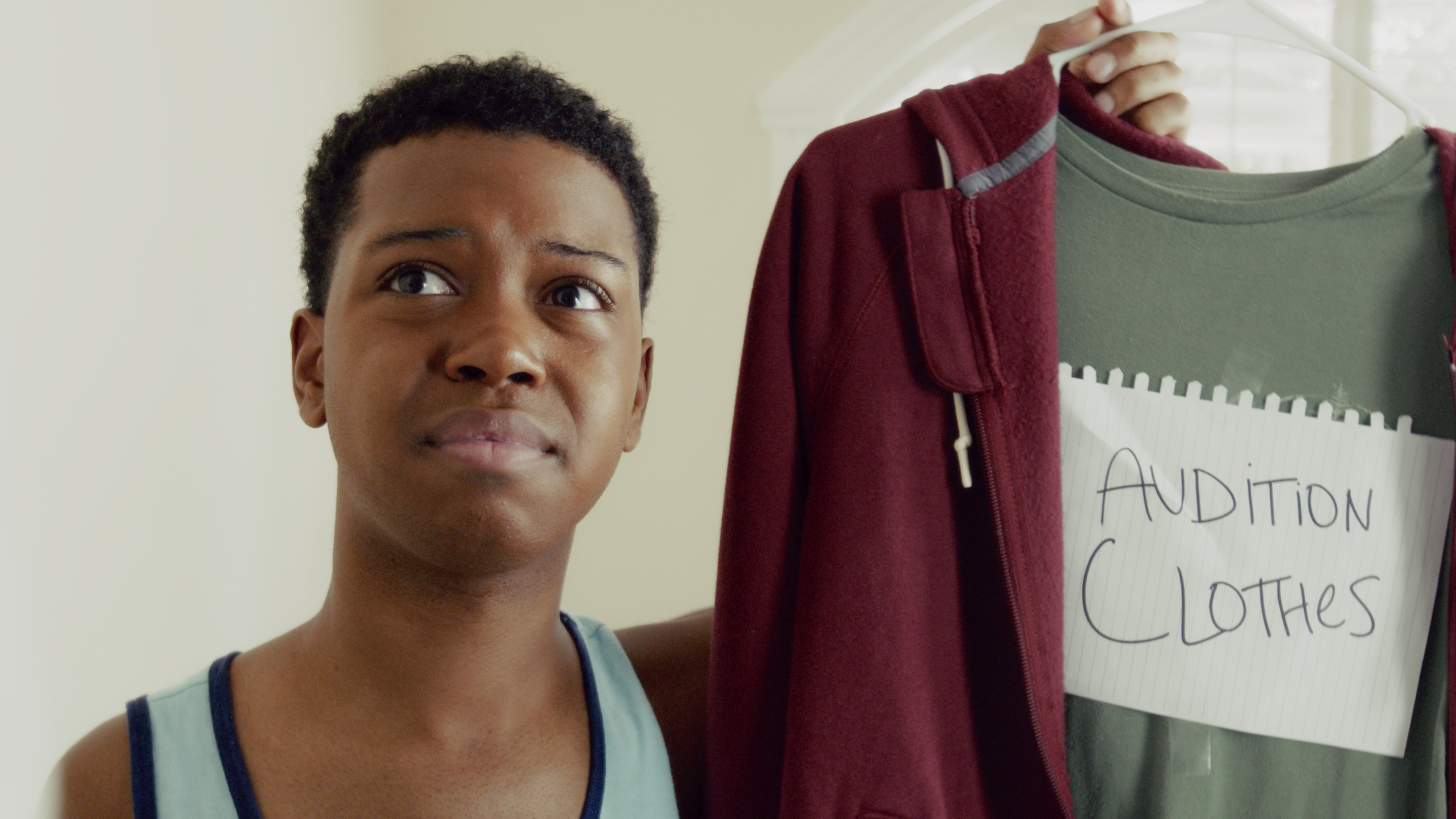 Sizing up the audition clothes. A green tee marked in marker.