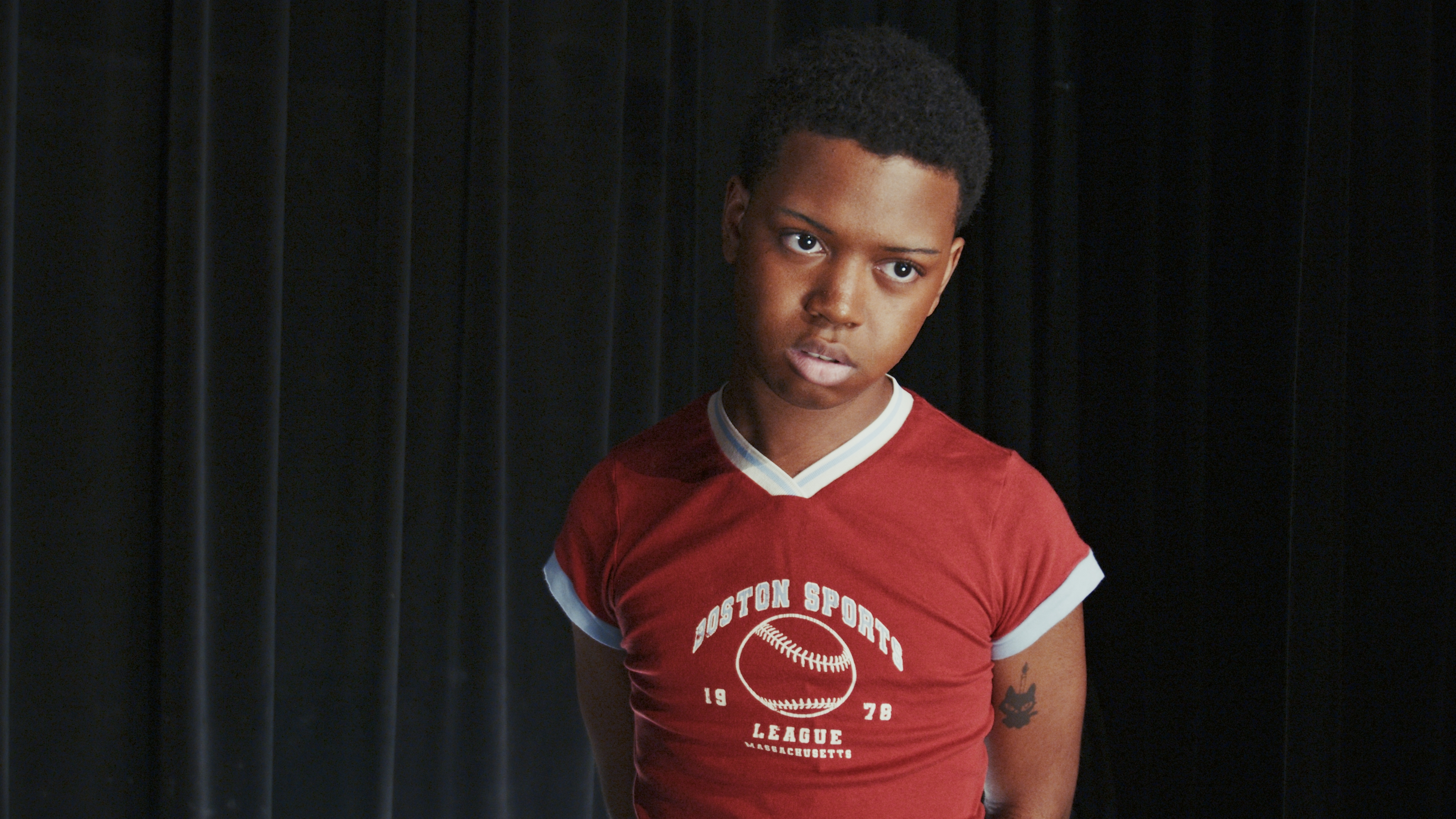 Boston Sports League jersey. Black curtain behind.