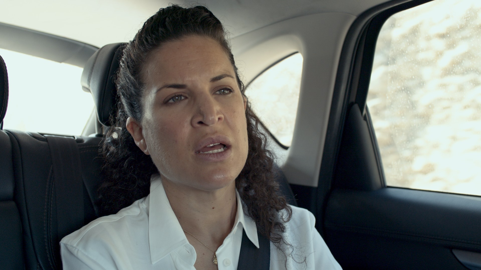 Backseat interview. Window light, white shirt.