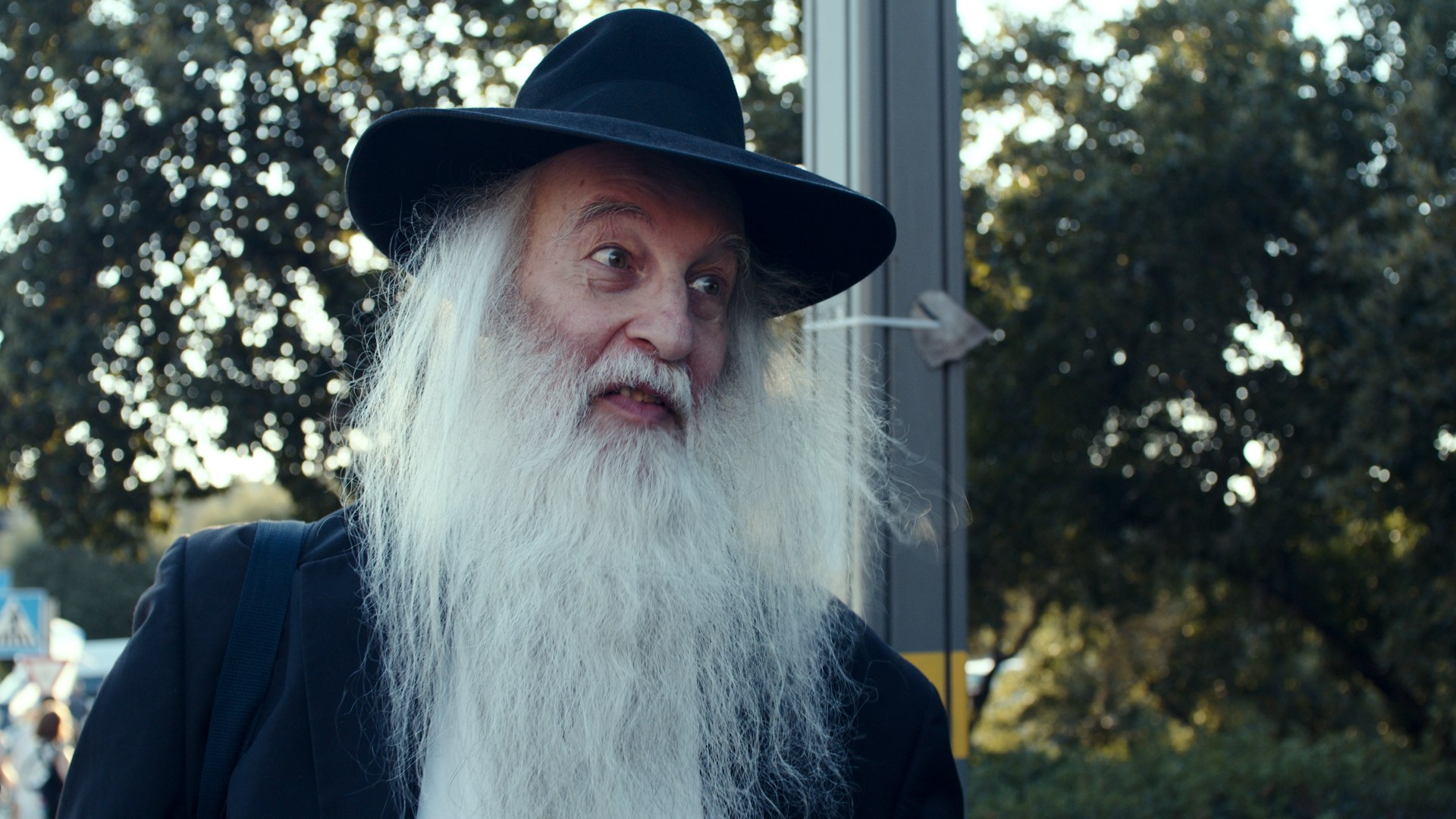 Older man, black hat, long white beard. Street.