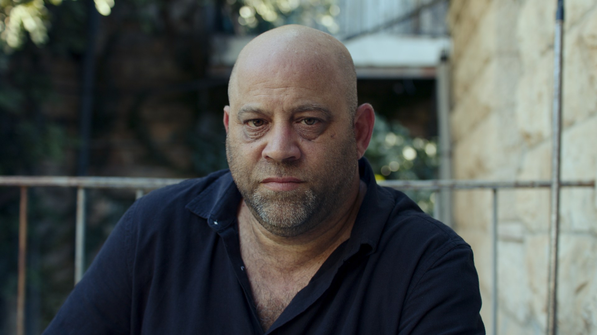 Portrait. Stone wall, navy shirt.