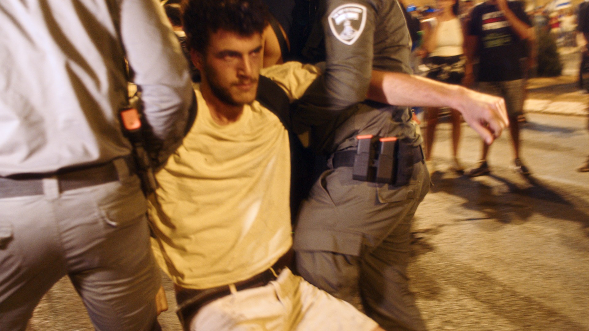Police lift a protester from the ground.